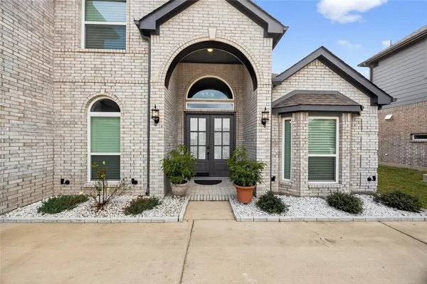 a view of a brick house with potted plants