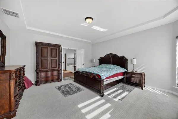 a bedroom with a bed and dresser with view