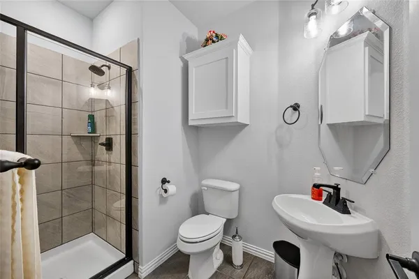 a bathroom with a sink a toilet and shower