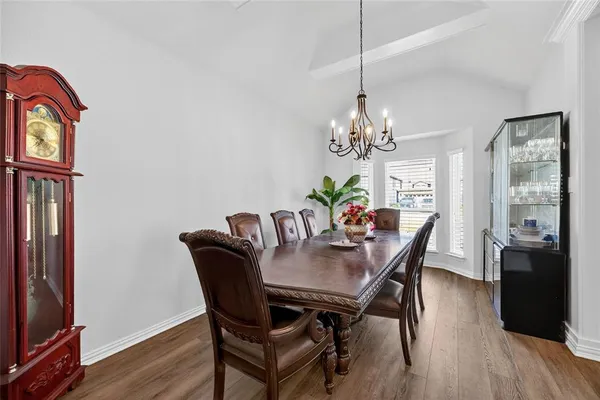a dining room with furniture a chandelier and wooden floor
