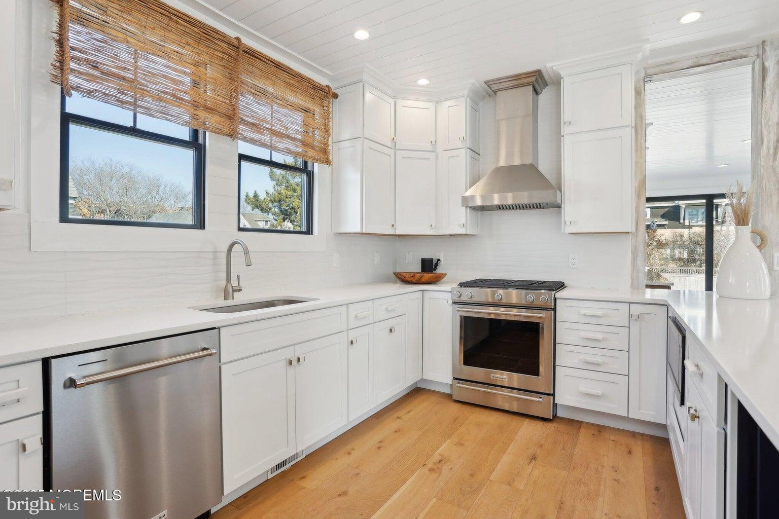 211 4th Street Beach Haven, NJ 08008 - Photo 12 of 48 a kitchen with stainless steel appliances white cabinets and a stove top oven
