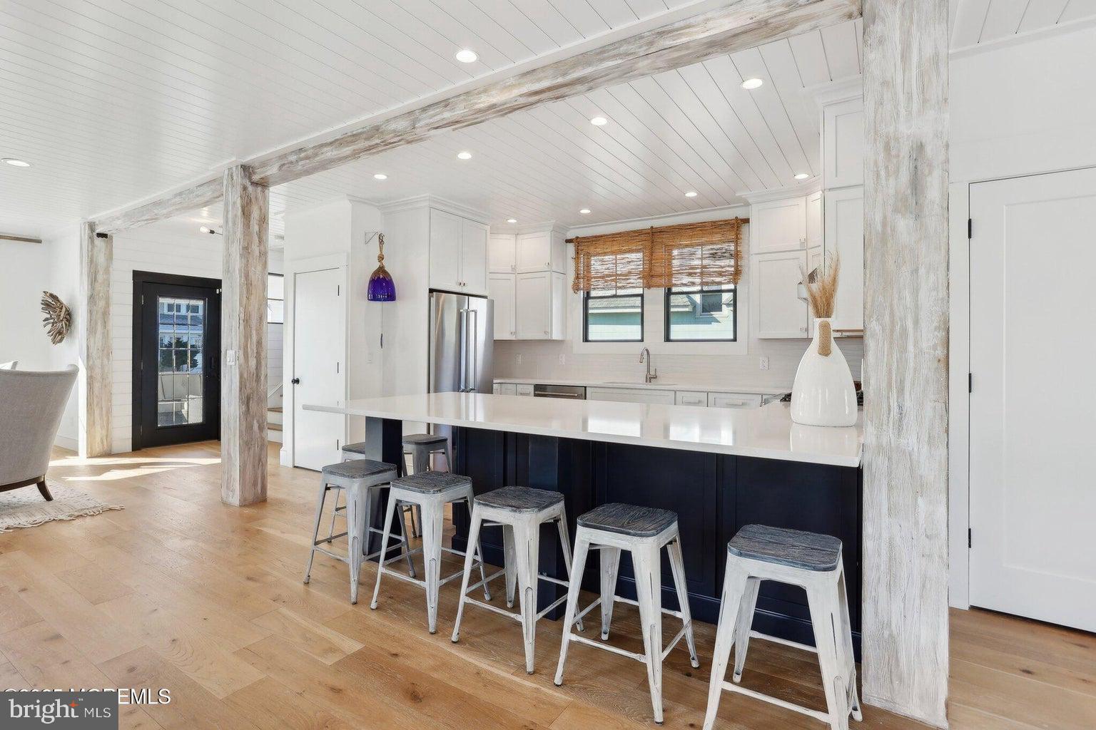 211 4th Street Beach Haven, NJ 08008 - Photo 9 of 48 a kitchen with a dining table chairs cabinets and wooden floor