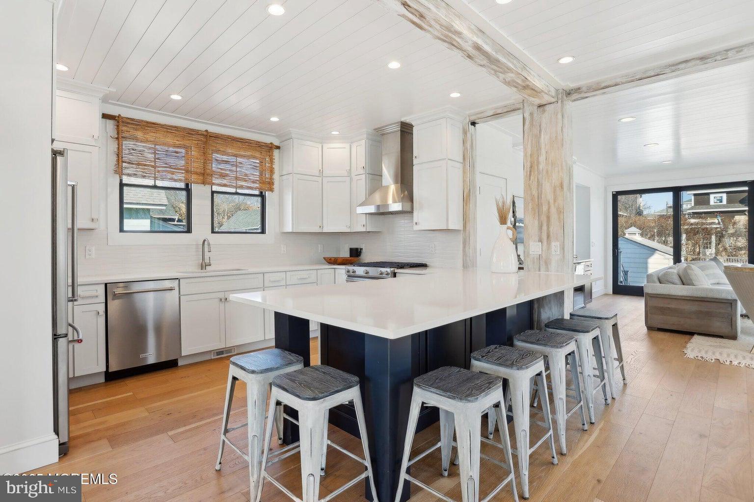 211 4th Street Beach Haven, NJ 08008 - Photo 10 of 48 a kitchen with stainless steel appliances kitchen island granite countertop a table chairs sink and cabinets