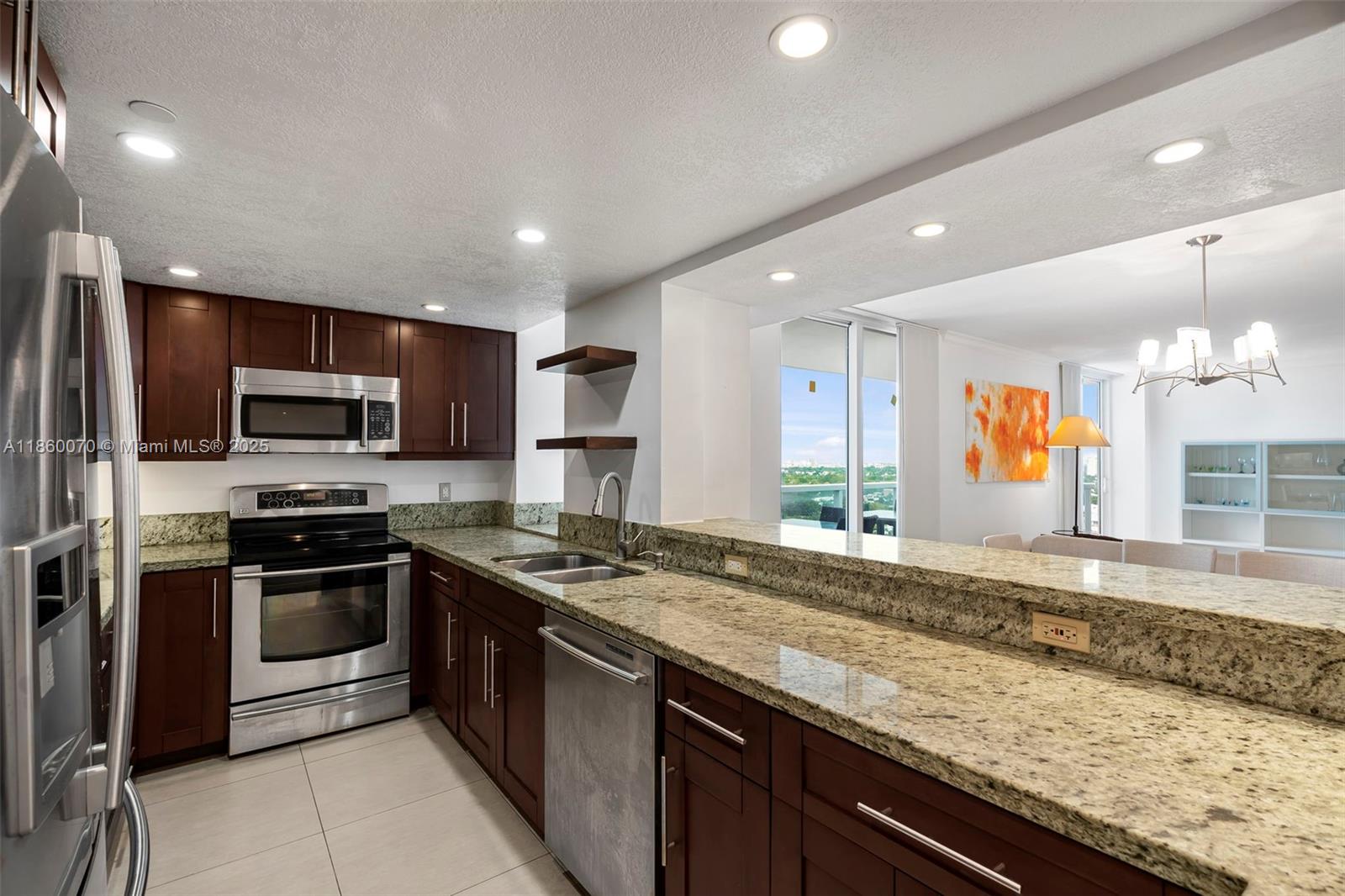 2401 Collins Avenue, Unit 1808 Miami Beach, FL 33140 - Photo 15 of 62 a kitchen with stainless steel appliances granite countertop a stove a sink and a microwave