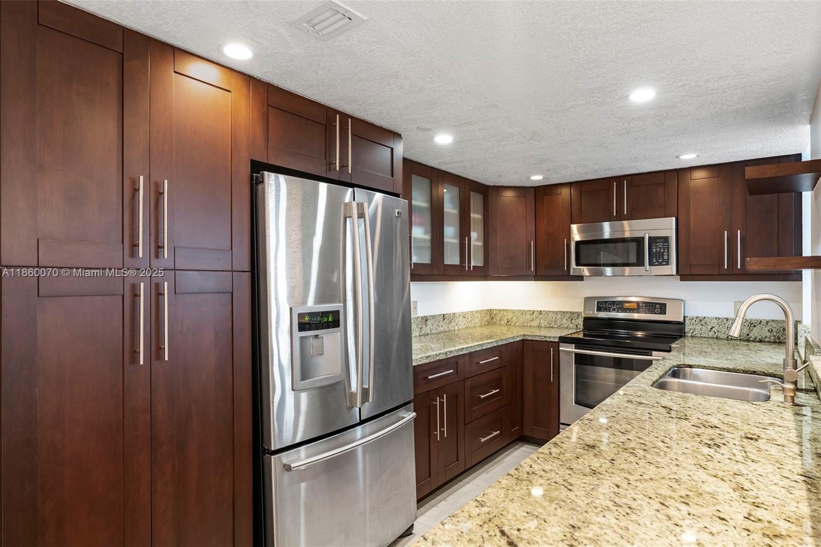 2401 Collins Avenue, Unit 1808 Miami Beach, FL 33140 - Photo 16 of 62 a kitchen with stainless steel appliances granite countertop a refrigerator and a sink