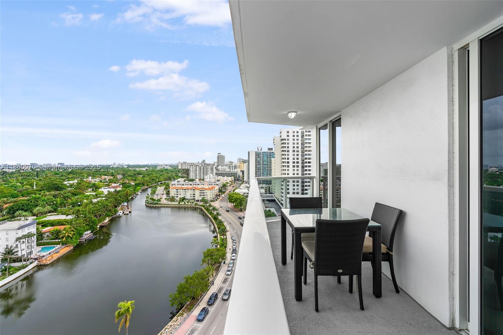 2401 Collins Avenue, Unit 1808 Miami Beach, FL 33140 - Photo 18 of 62 a view of a balcony with table and chairs