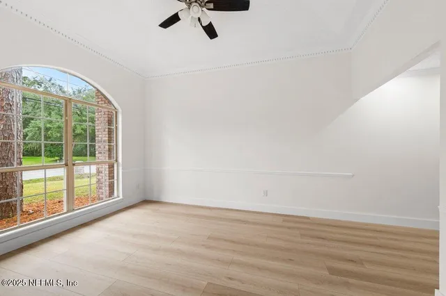 an empty room with windows and fireplace