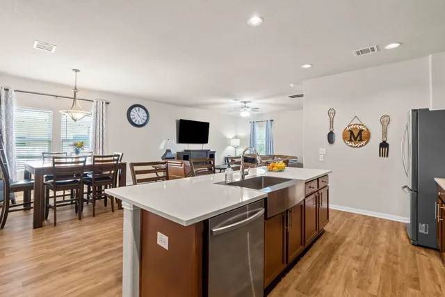 a kitchen with a wooden floor and chairs