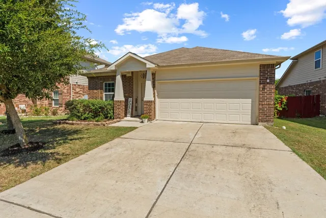 a view of a white house with a yard and large tree