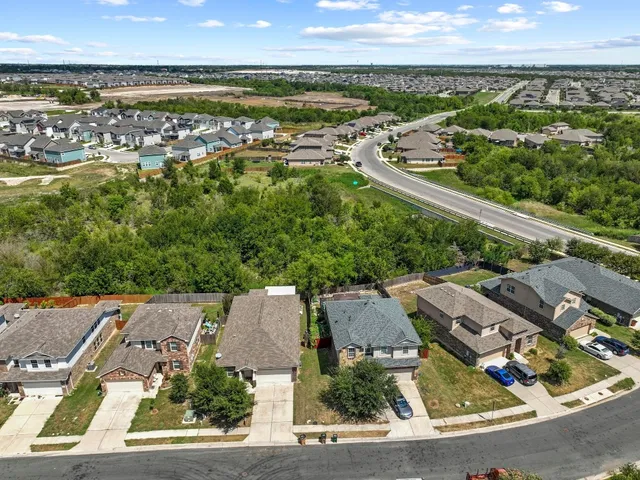 an aerial view of residential houses with outdoor space and ocean view
