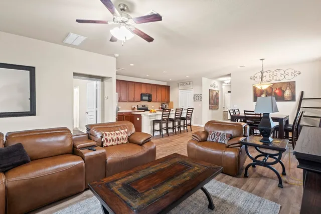 a living room with furniture kitchen view and a chandelier