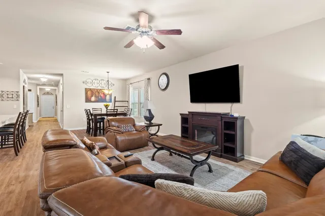 a living room with furniture a flat screen tv and a fireplace