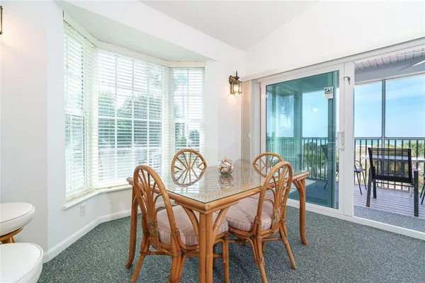 a view of a dining room with furniture large windows and wooden floor