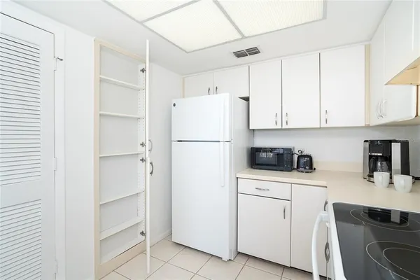 a kitchen with white cabinets and white appliances