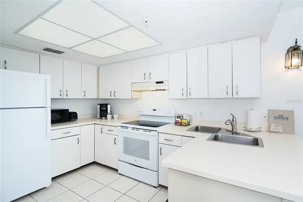 a kitchen with white cabinets sink and white appliances