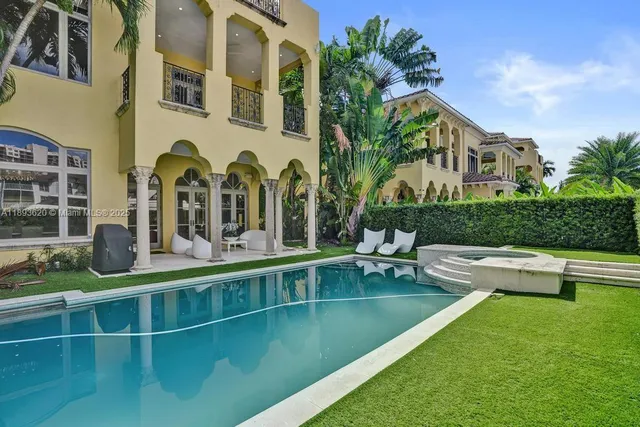 a view of pool with lawn chairs and large trees