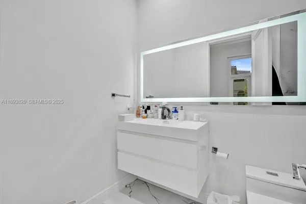 a picture of a bathroom with a white wall