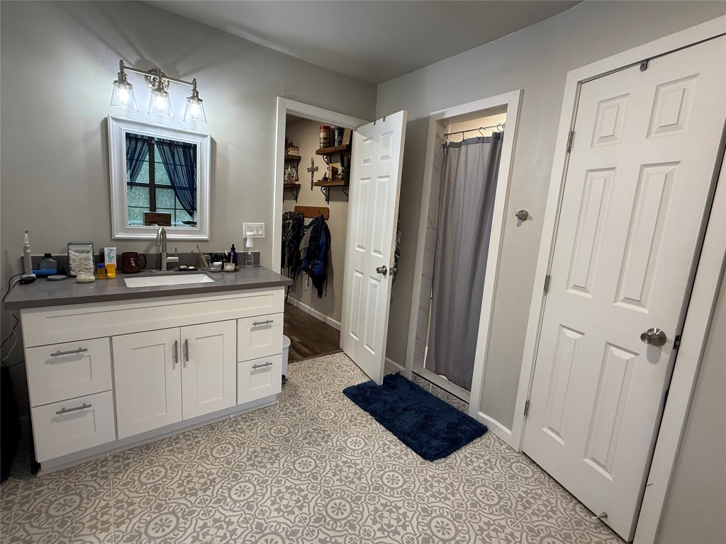 25 Ridge Top Drive Huntsville, TX 77320 - Photo 12 of 19 a spacious bathroom with a sink a mirror and a shower