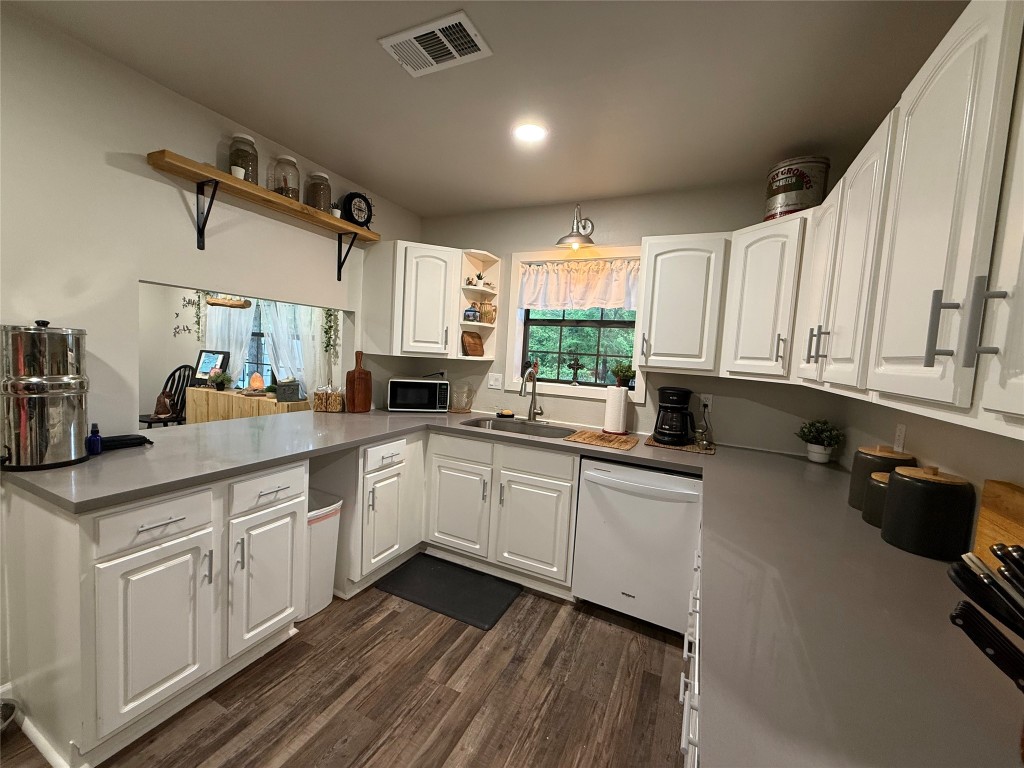 25 Ridge Top Drive Huntsville, TX 77320 - Photo 5 of 19 a kitchen with a sink dishwasher white cabinets and black appliances