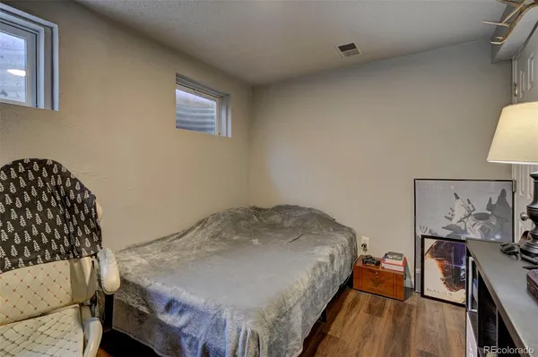 a bed sitting in a bedroom next to a window with wooden floor