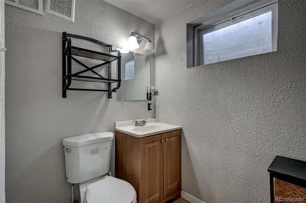 a bathroom with a toilet a sink and mirror