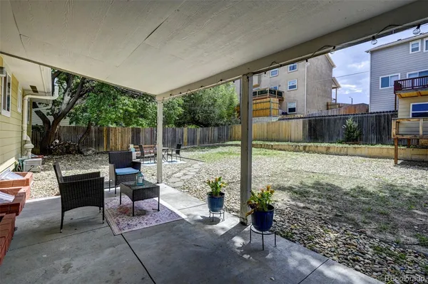 a view of a patio with table and chairs potted plants with floor to ceiling window and wooden floor