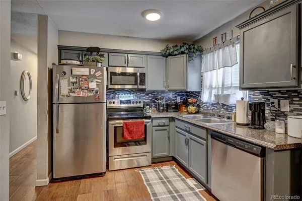 a kitchen with stainless steel appliances granite countertop a refrigerator sink and microwave