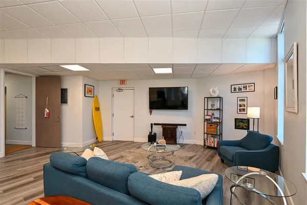 a living room with lots of chairs and a wooden floor