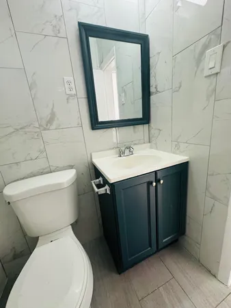 a bathroom with a toilet sink and mirror