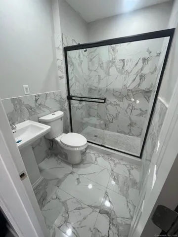 a bathroom with a granite countertop sink toilet and shower