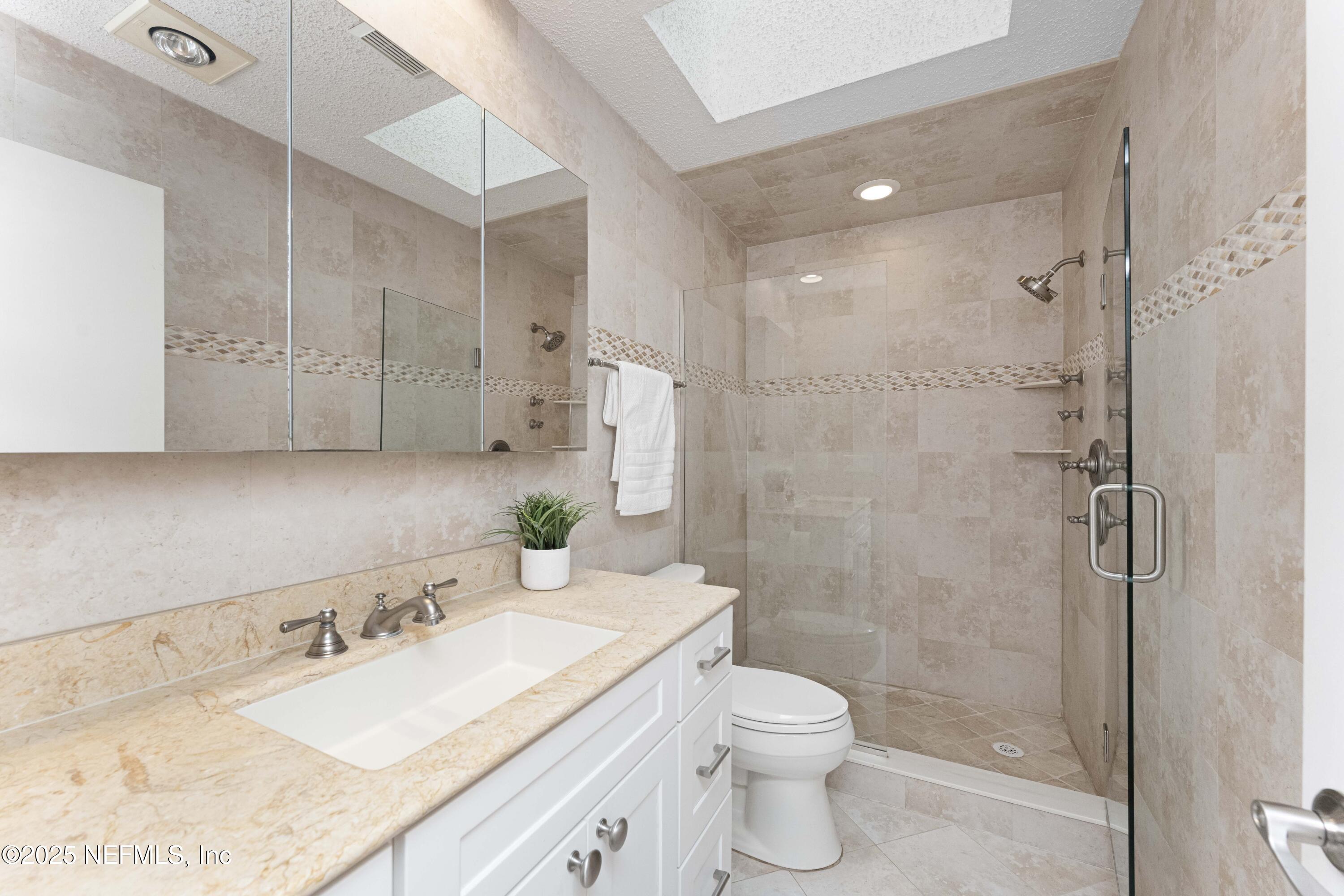 372 4th Street Atlantic Beach, FL 32233 - Photo 36 of 77 a bathroom with a granite countertop sink a toilet and shower