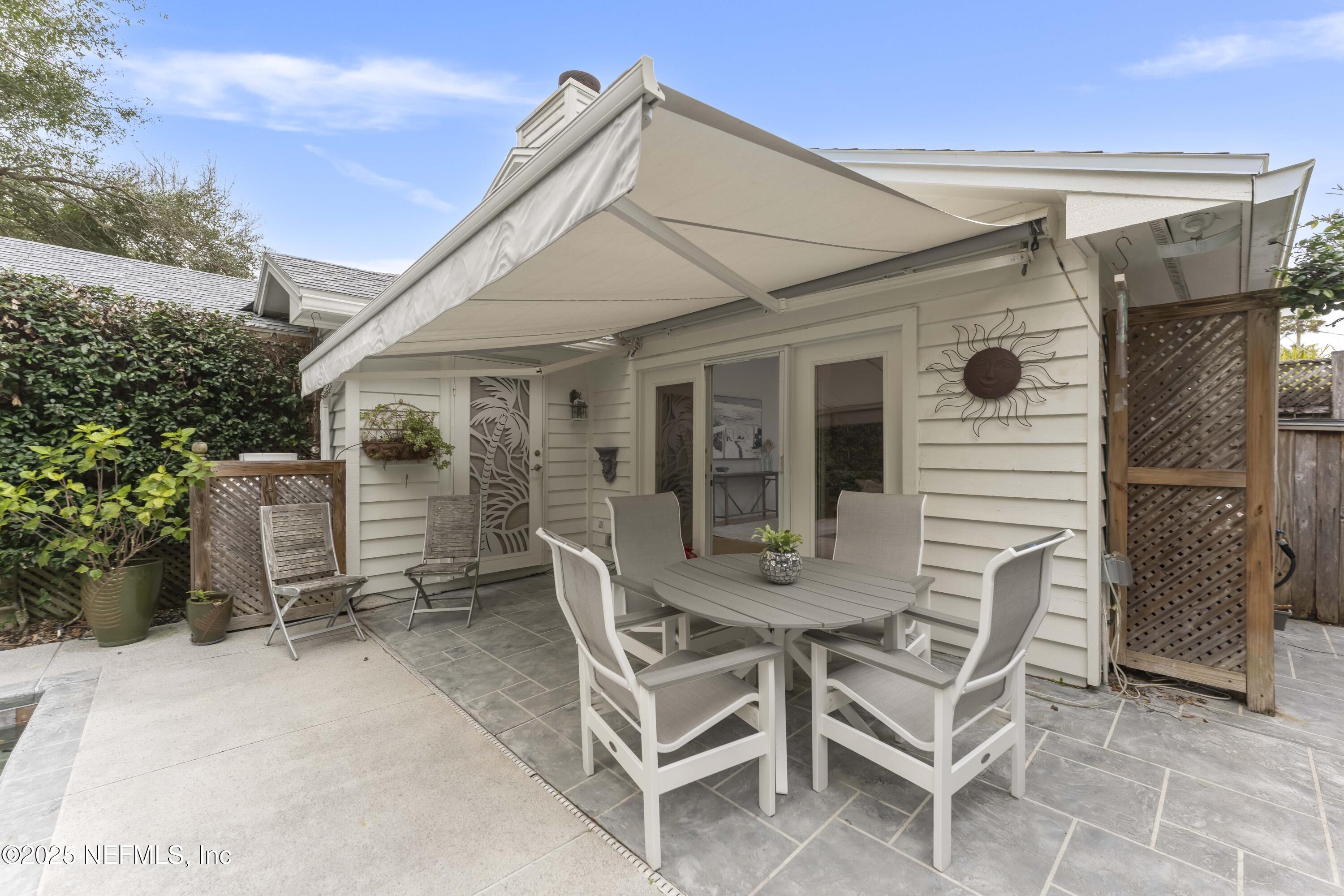 372 4th Street Atlantic Beach, FL 32233 - Photo 38 of 77 a view of a patio with table and chairs and wooden fence