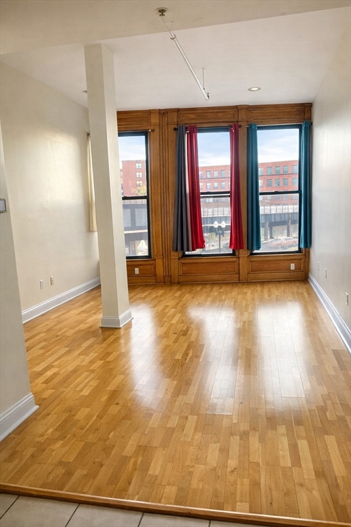 7 Central Square, Unit 203 Lynn, MA 01901 - Photo 2 of 13 an empty room with wooden floor and windows