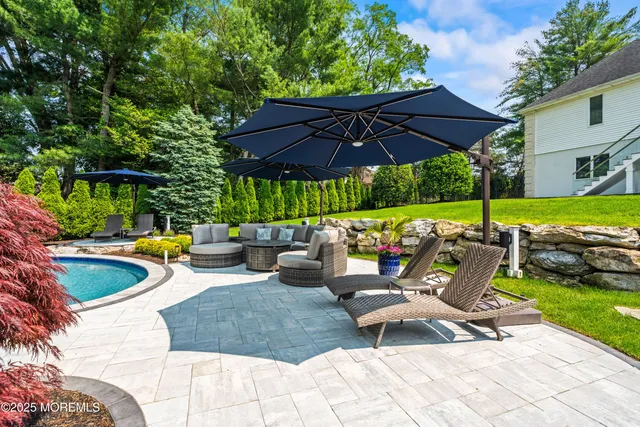 a view of backyard with swimming pool and table