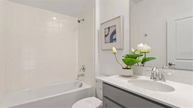 a bathroom with a granite countertop sink a toilet and shower