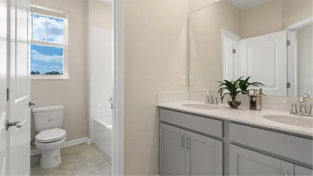 a bathroom with a granite countertop sink a toilet and a mirror