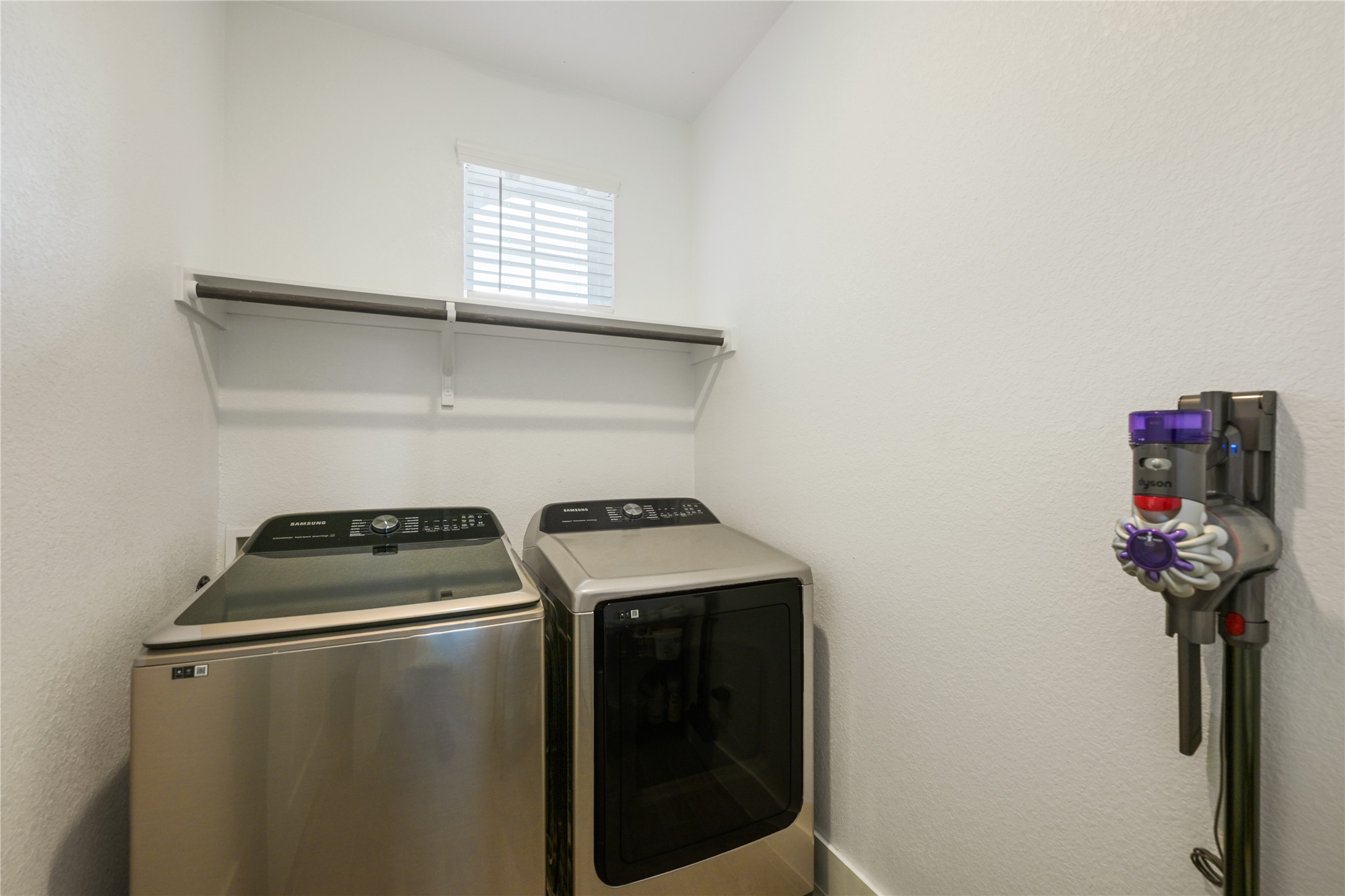 238 Wild Pecan Loop Buda, TX 78610 - Photo 24 of 31 A practical laundry space features built-in wire shelving and a bright window.