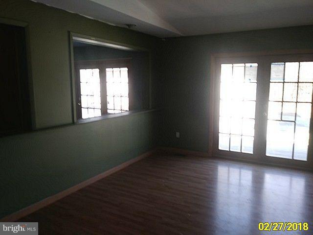 13028 Oliver Beach Road Baltimore, MD 21220 - Photo 11 of 21 a view of an empty room with wooden floor and a window