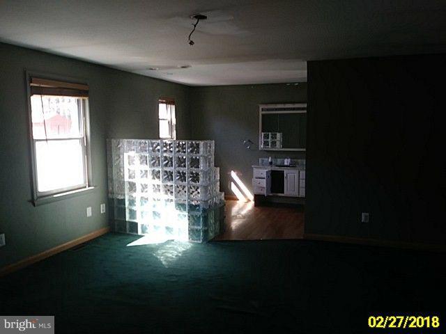13028 Oliver Beach Road Baltimore, MD 21220 - Photo 18 of 21 a view of empty room with wooden floor and fan
