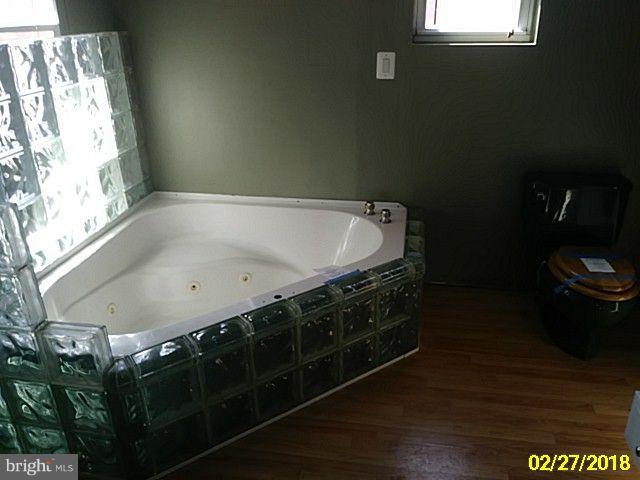 13028 Oliver Beach Road Baltimore, MD 21220 - Photo 19 of 21 a bathroom with a bathtub and a toilet