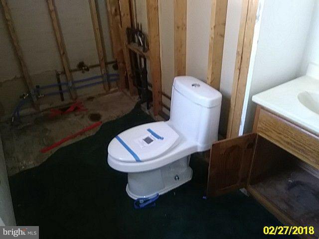 13028 Oliver Beach Road Baltimore, MD 21220 - Photo 21 of 21 a white toilet sitting next to a shower curtain