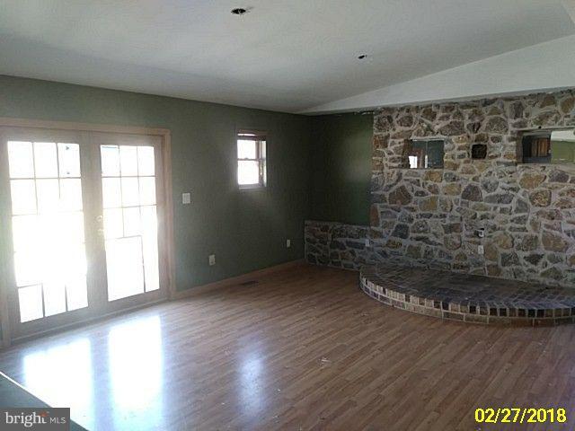 13028 Oliver Beach Road Baltimore, MD 21220 - Photo 8 of 21 a view of empty room with wooden floor and fan