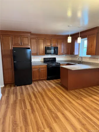 a kitchen with granite countertop a refrigerator and a sink
