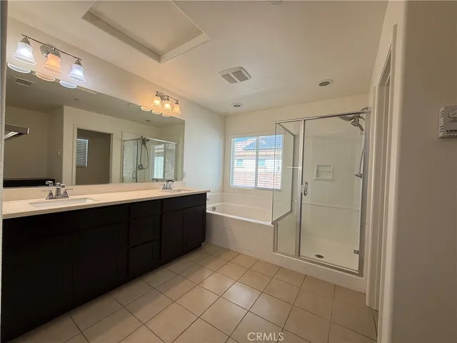 a spacious bathroom with a double vanity sink a mirror and a bathtub