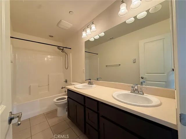 a bathroom with a sink a toilet a mirror and shower