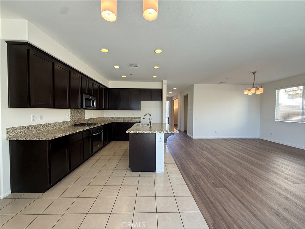 12319 Twin Gables Drive Chino, CA 91710 - Photo 9 of 42 a kitchen with stainless steel appliances granite countertop a refrigerator a sink dishwasher a stove and a microwave oven on the blue kitchen countertops with wooden floor