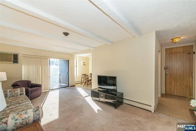 a living room with furniture a flat screen tv and a window