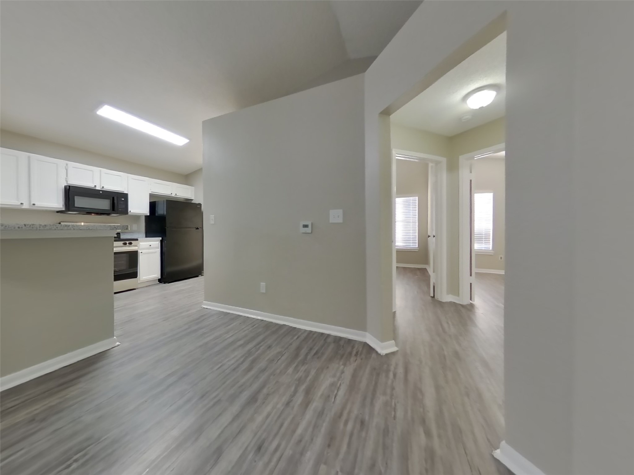 3151 Kelling Street Houston, TX 77045 - Photo 5 of 16 a view of a kitchen with a refrigerator a stove top oven and wooden floor