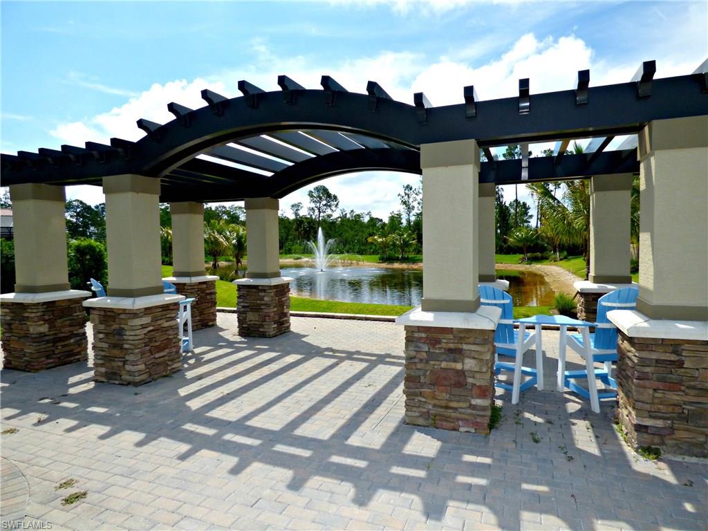 16325 Aberdeen Way Naples, FL 34110 - Photo 22 of 24 a view of a patio with a dining table and chairs with wooden floor