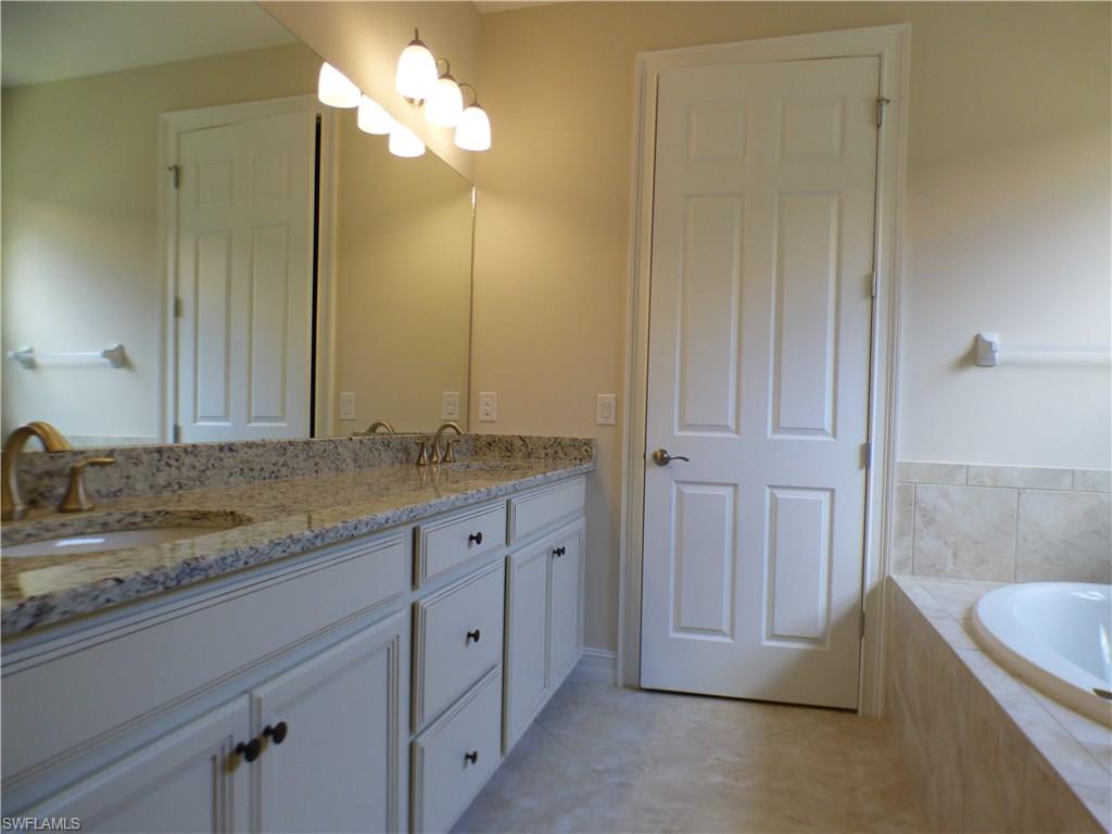 16325 Aberdeen Way Naples, FL 34110 - Photo 6 of 24 a bathroom with a granite countertop sink and a mirror